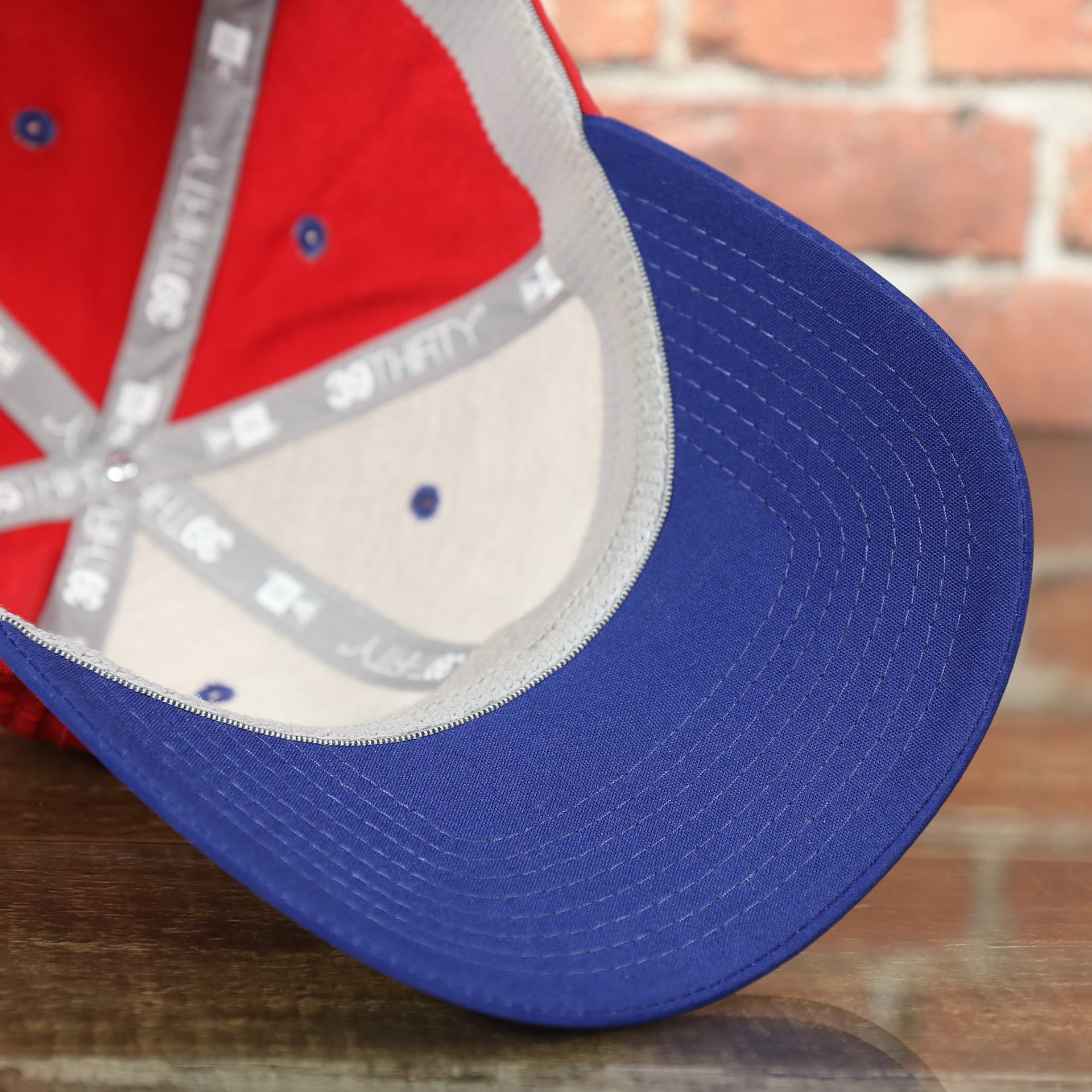 blue undervisor on the Philadelphia Phillies Team Classic Blue on Red 39Thirty Stretch Fit Cap