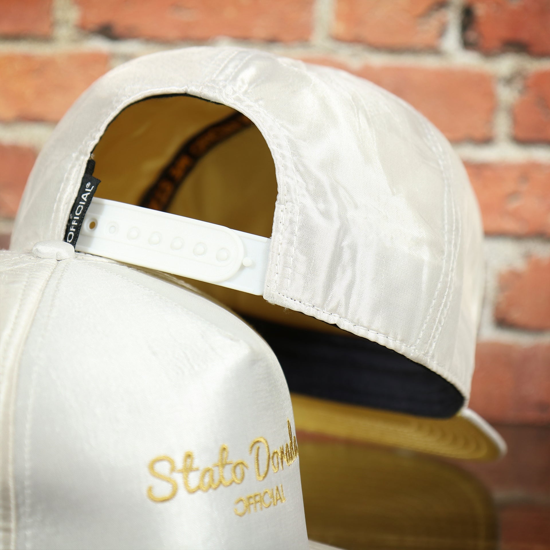 white adjustable snap on the Official Stato Dorado Blanco Satin Snapback Hat