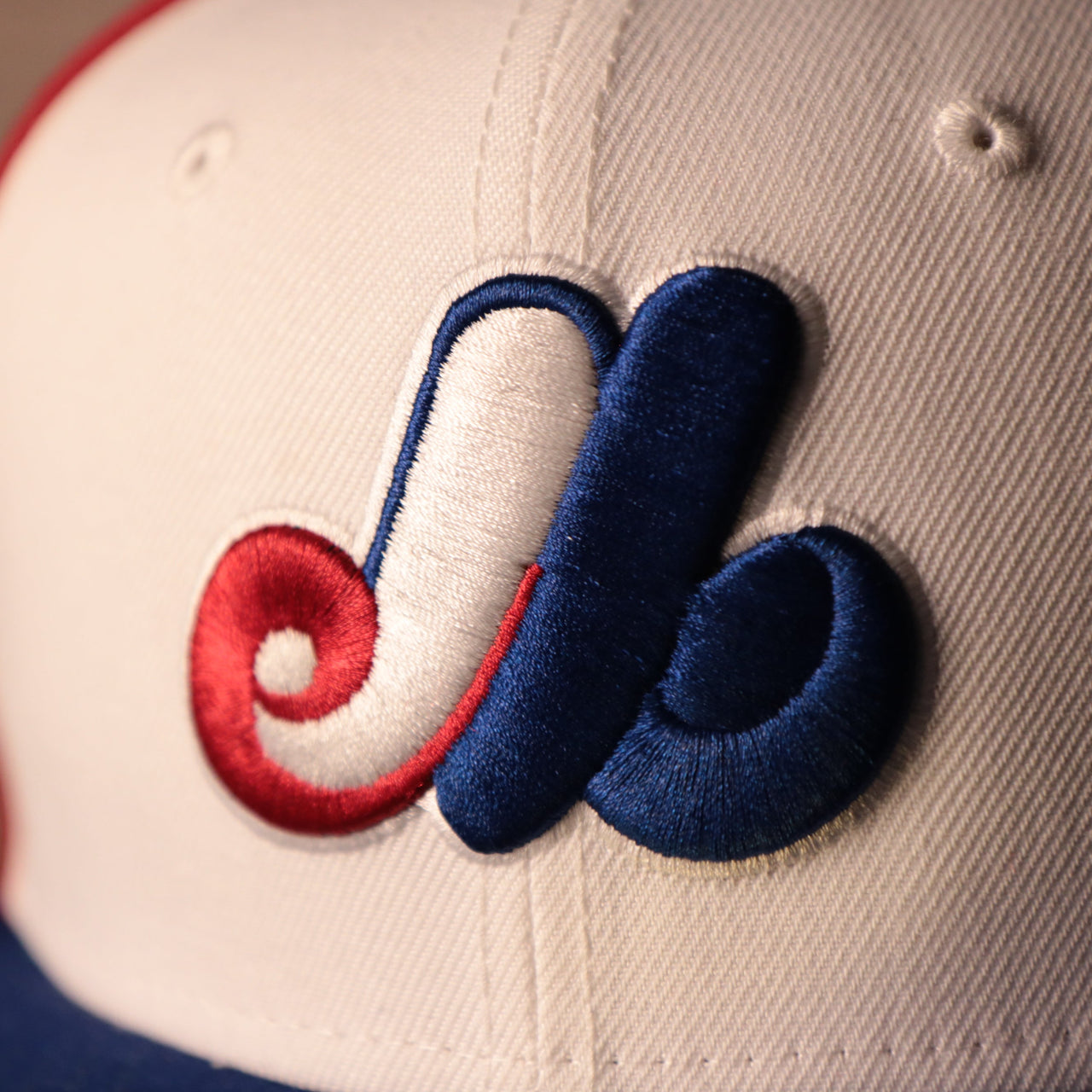 The white, red, and blue logo of the Expos on the front side of the 1969 pinwheel retro fitted hat by New Era.