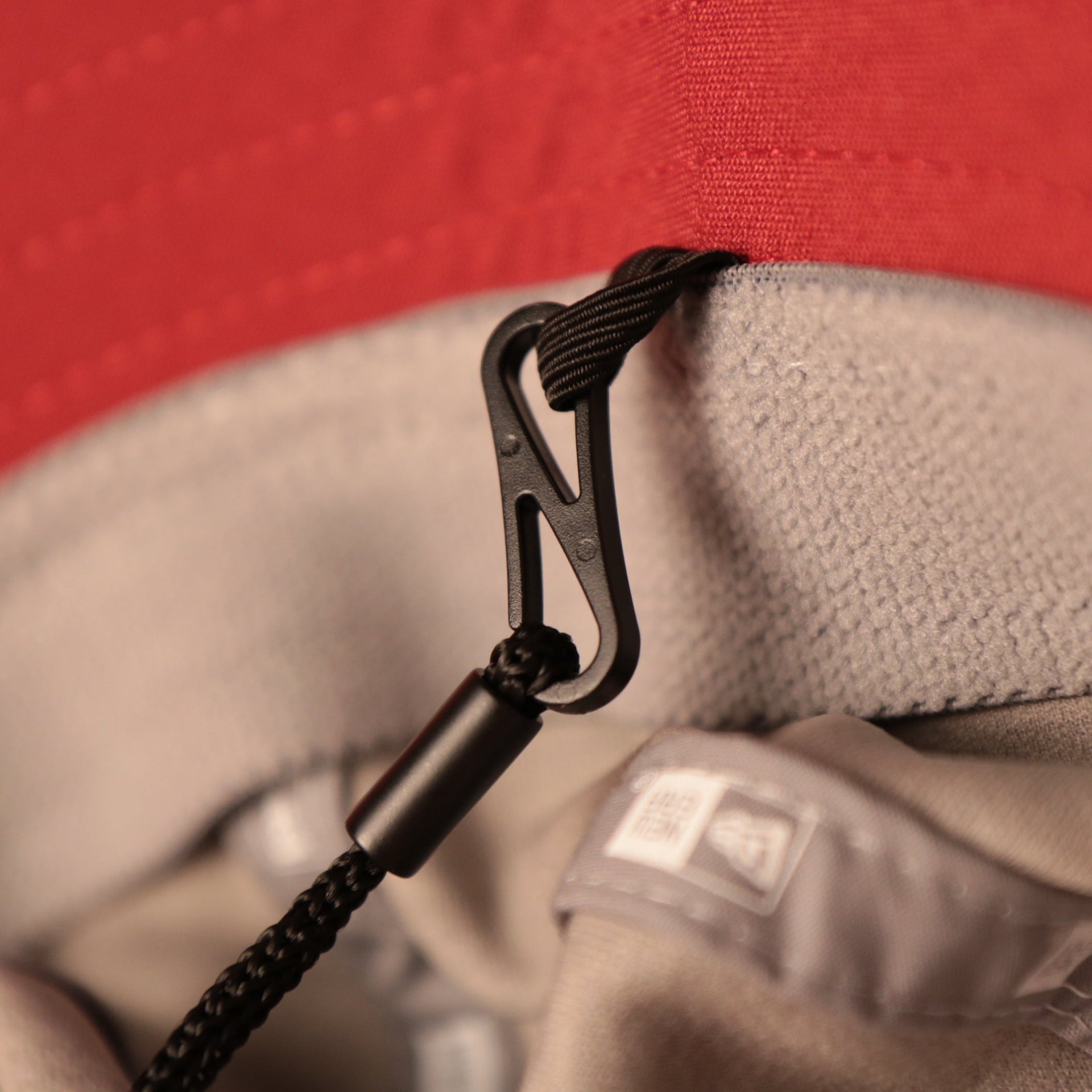 A closeup shot of the adjustable strings of the gray nfl training arizonal cardinal bucket hats by New Era.