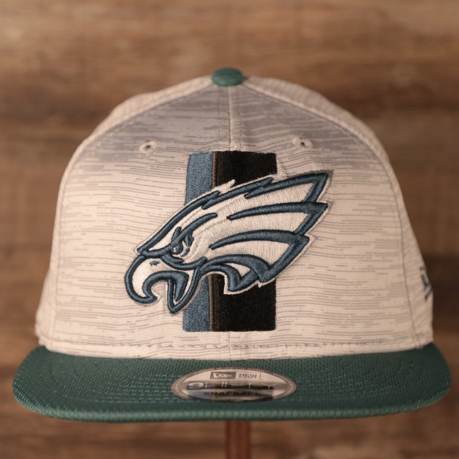 The Eagles patch on the front side of the New Era training 2021 gray snapback hat.