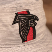 A closeup shot of the Atlanta Falcons patch of the gray nfl on field training bucket hat by New Era.