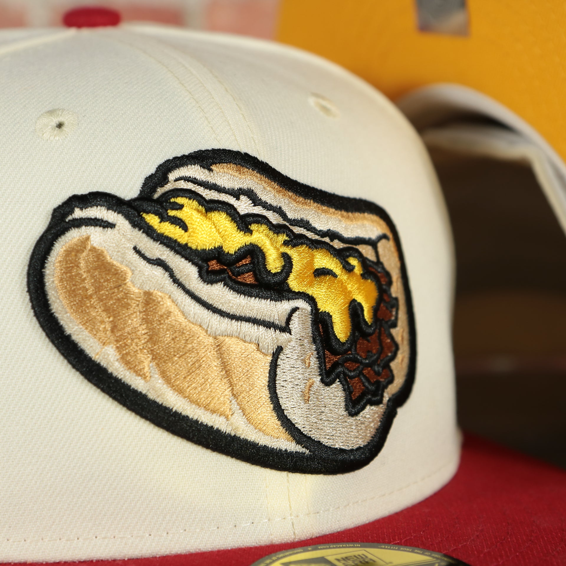 Close up of the logo on the Lehigh Valley Iron Pigs Cheesesteak Without Onions Yellow UV Plain Jane 59Fifty Fitted Cap | Cap Swag Exclusive