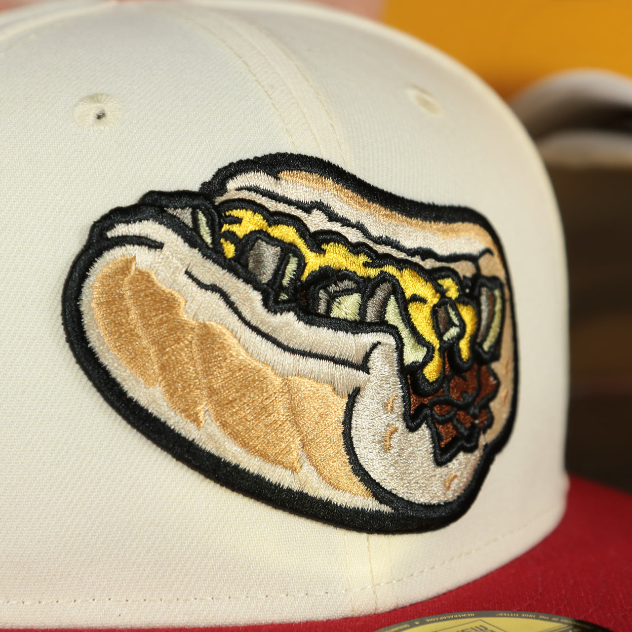 Close up of the front logo on the Lehigh Valley Iron Pigs Cheesesteak With Onions Yellow UV Plain Jane 59Fifty Fitted Cap | nohiosafariclub Exclusive