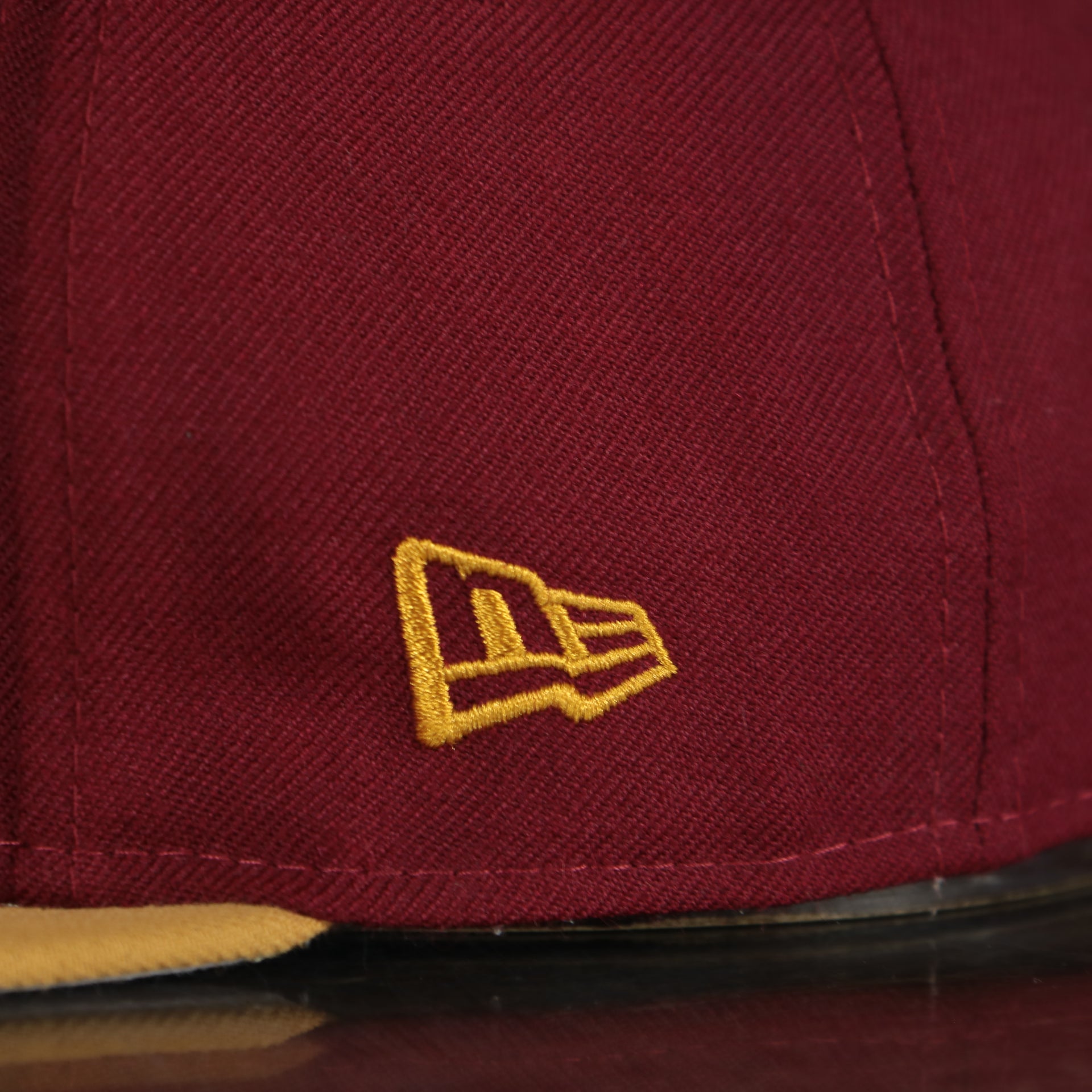new era log on the side of the New Jersey "NJ" Hat | New Jersey Garden State 9Fifty Gray Bottom Snapback Hat | Maroon / Gold *DISCOLORED