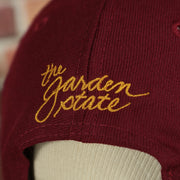 the garden state logo on the backside of the New Jersey "NJ" Hat | New Jersey Garden State 9Fifty Gray Bottom Snapback Hat | Maroon / Gold *DISCOLORED