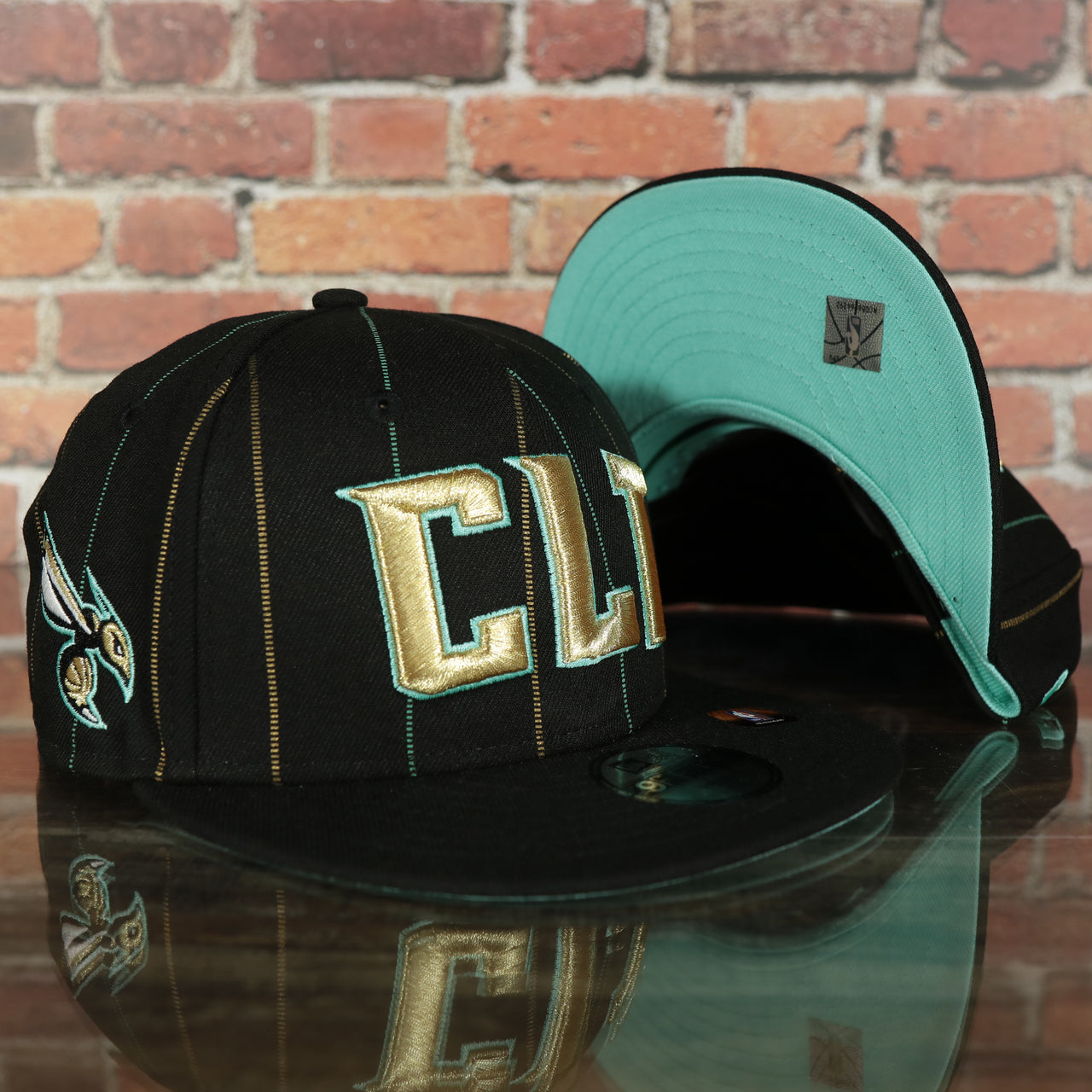 front and bottom of the Charlotte Hornets 2022 City Edition CLT Logo Teal Bottom Youth 9Fifty Side Patch Snapback Cap | New Era, Black