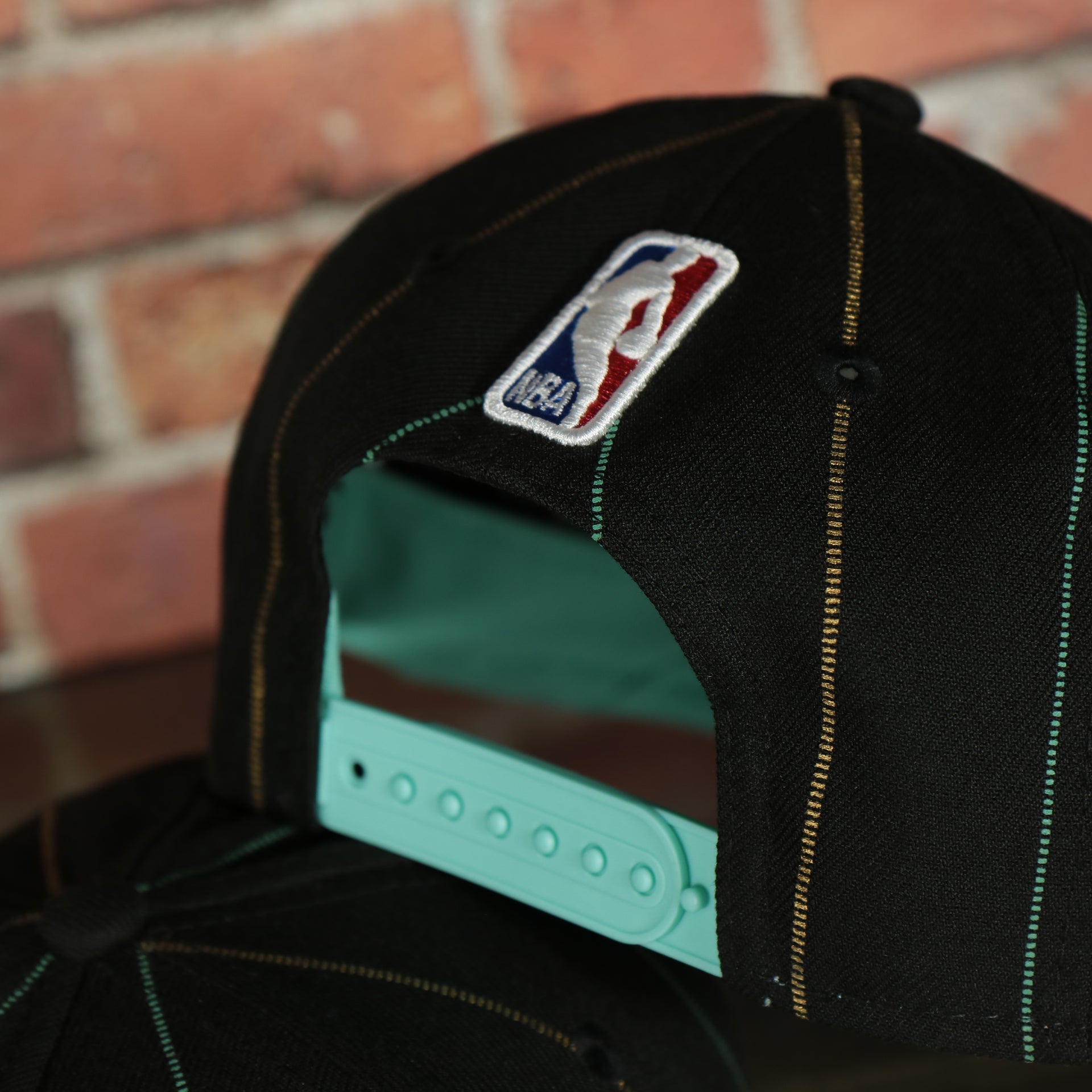 backside of the Charlotte Hornets 2022 City Edition CLT Logo Teal Bottom Youth 9Fifty Side Patch Snapback Cap | New Era, Black