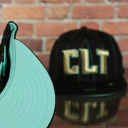 underside of the Charlotte Hornets 2022 City Edition CLT Logo Teal Bottom Youth 9Fifty Side Patch Snapback Cap | New Era, Black