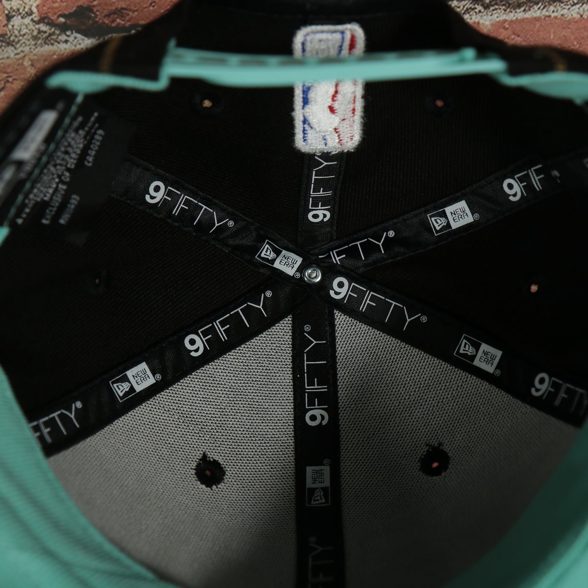 inside taping on the inside of the Charlotte Hornets 2022 City Edition CLT Logo Teal Bottom Youth 9Fifty Side Patch Snapback Cap | New Era, Black