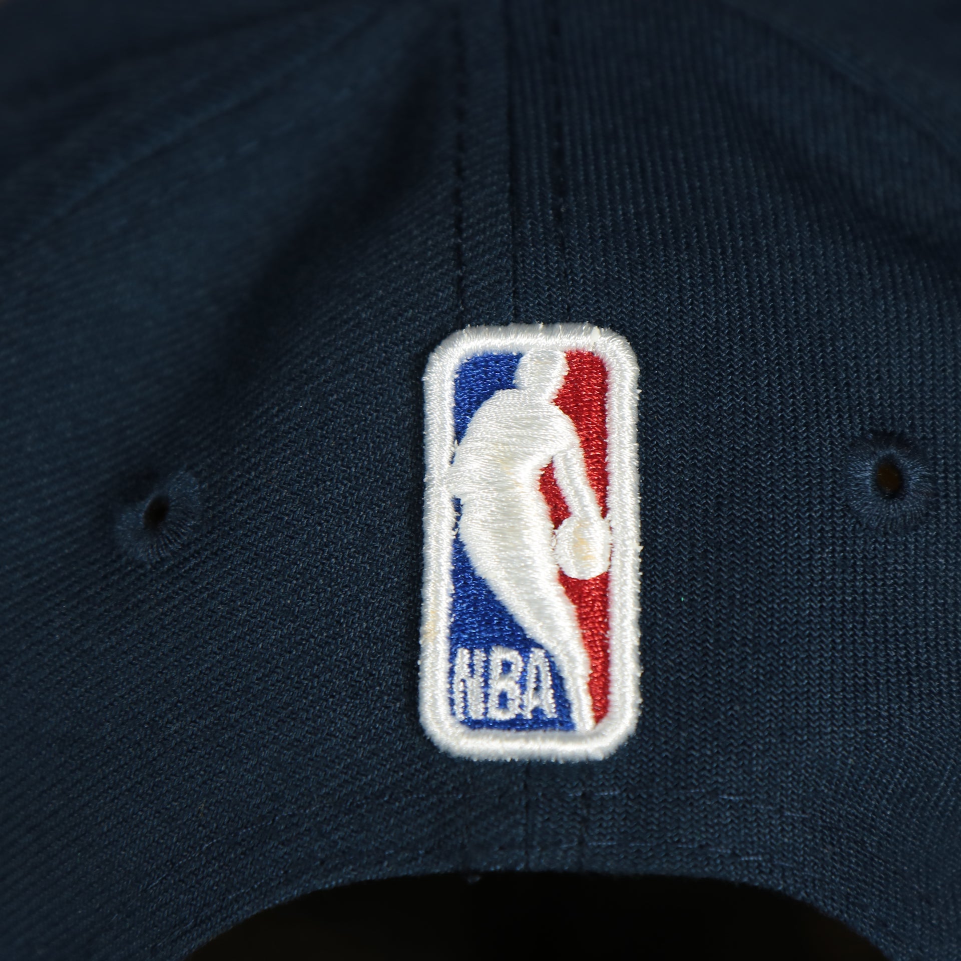 nba logo on the backside of the New Orleans Pelicans 2022 City Edition NOLA Logo Yellow Bottom Youth 9Fifty Side Patch Snapback Cap | New Era, Navy