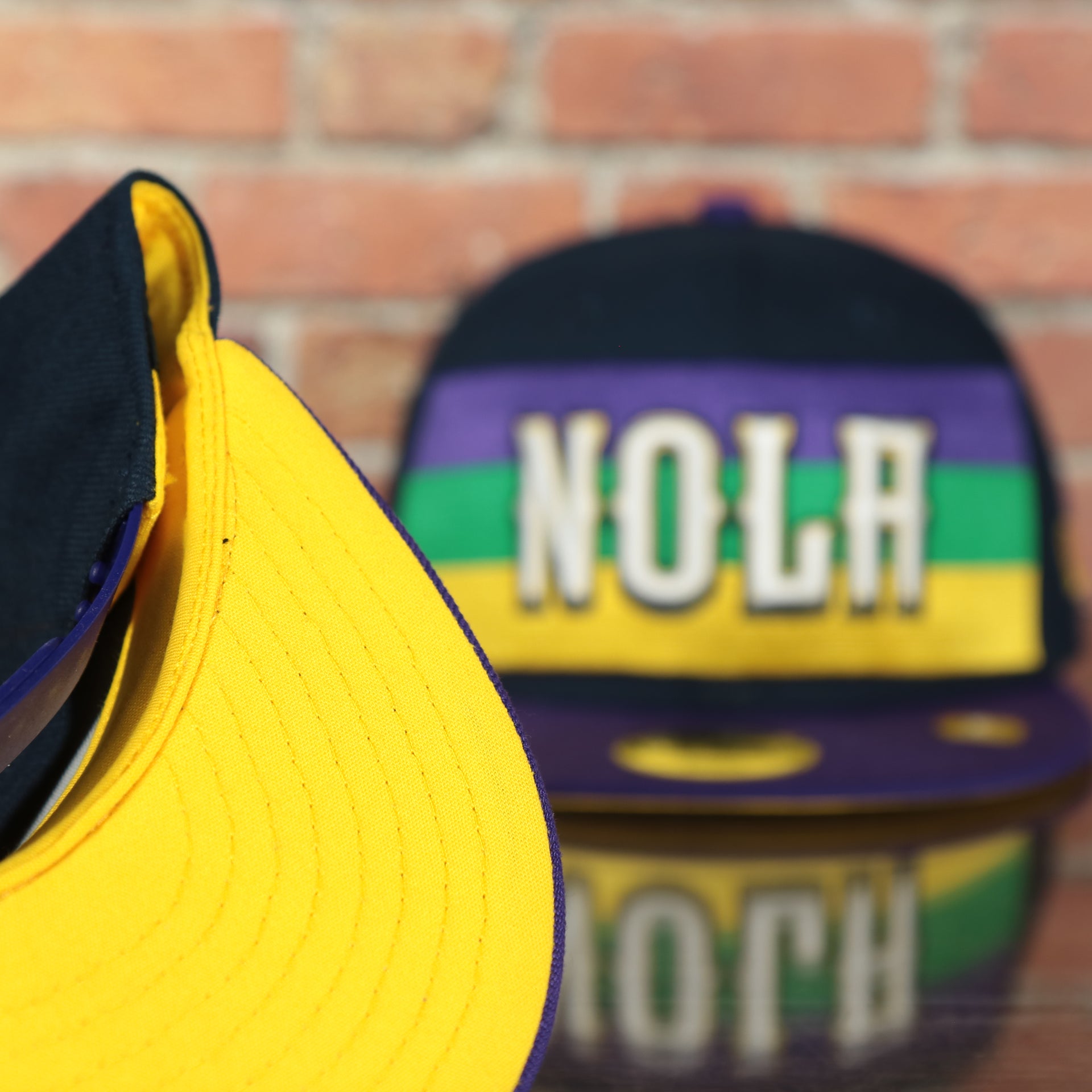 yellow underside of the New Orleans Pelicans 2022 City Edition NOLA Logo Yellow Bottom Youth 9Fifty Side Patch Snapback Cap | New Era, Navy