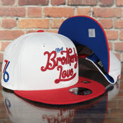 front and bottom of the Philadelphia 76ers 2022 City Edition City Of Brotherly Love Blue Bottom Youth 9Fifty Side Patch Snapback Cap | New Era, White