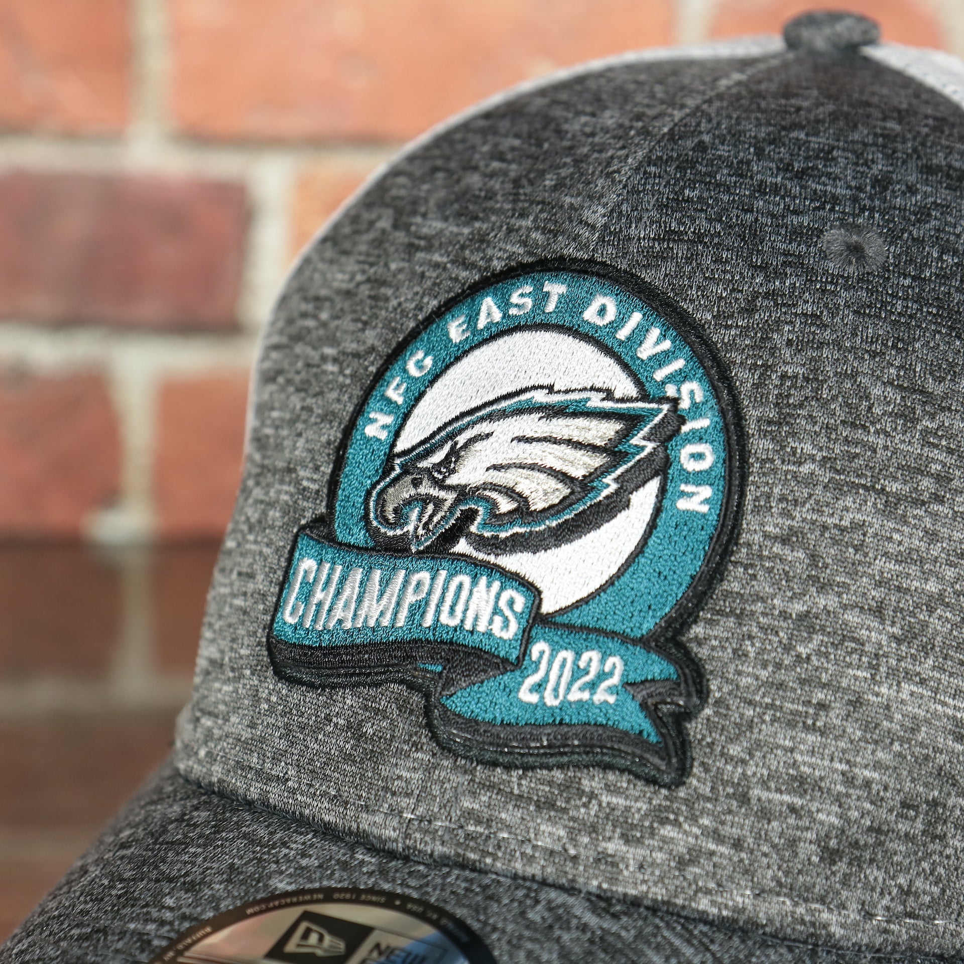 Close up of the NFC East Division Champions 2022 patch on the front of the Philadelphia Eagles 2022 NFC East Division Champions Locker Room Official On Field 9Forty Mesh Trucker Hat