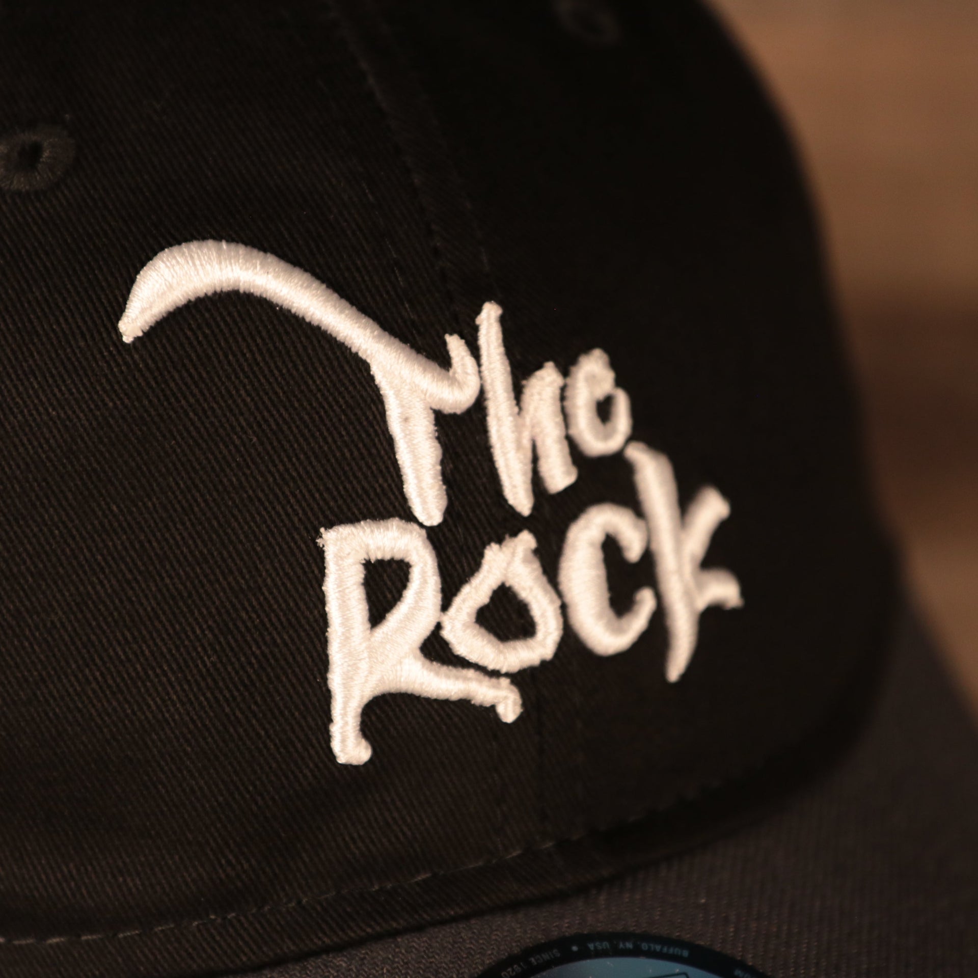 The Rock lettering on the front of the Dwayne "The Rock" Johnson Vintage WWE 9Twenty Dad Hat