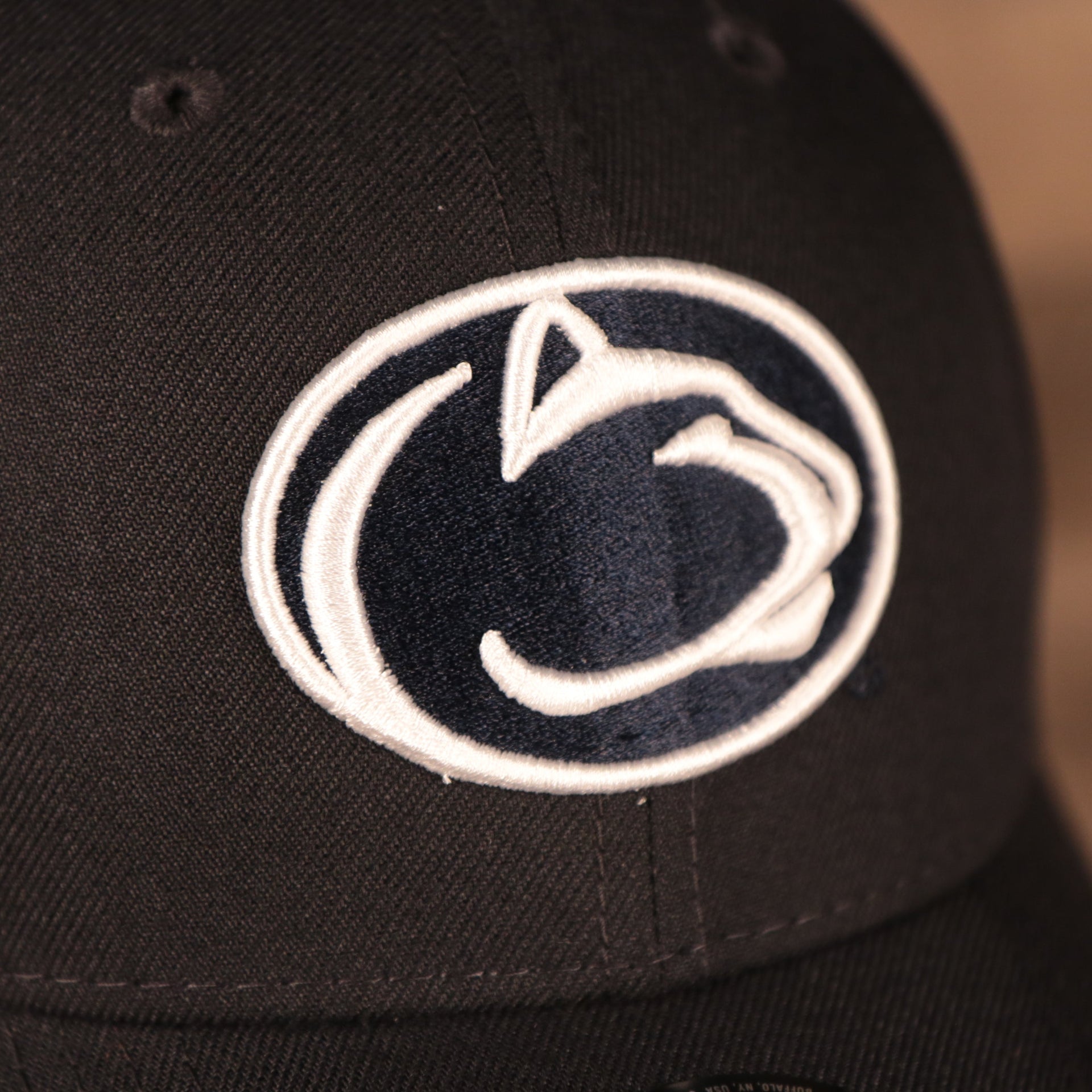 Close up of the Penn State Nittany Lions logo embroidered on the front of the Penn State Nittany Lions The League 940 9Forty Adjustable Dad Hat