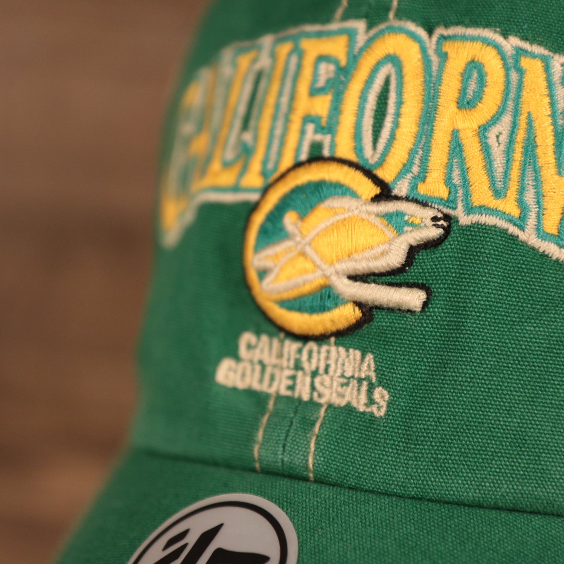 logo shot on the California Golden Seals Green and Yellow Retro Adjustable Trucker Dad Hat