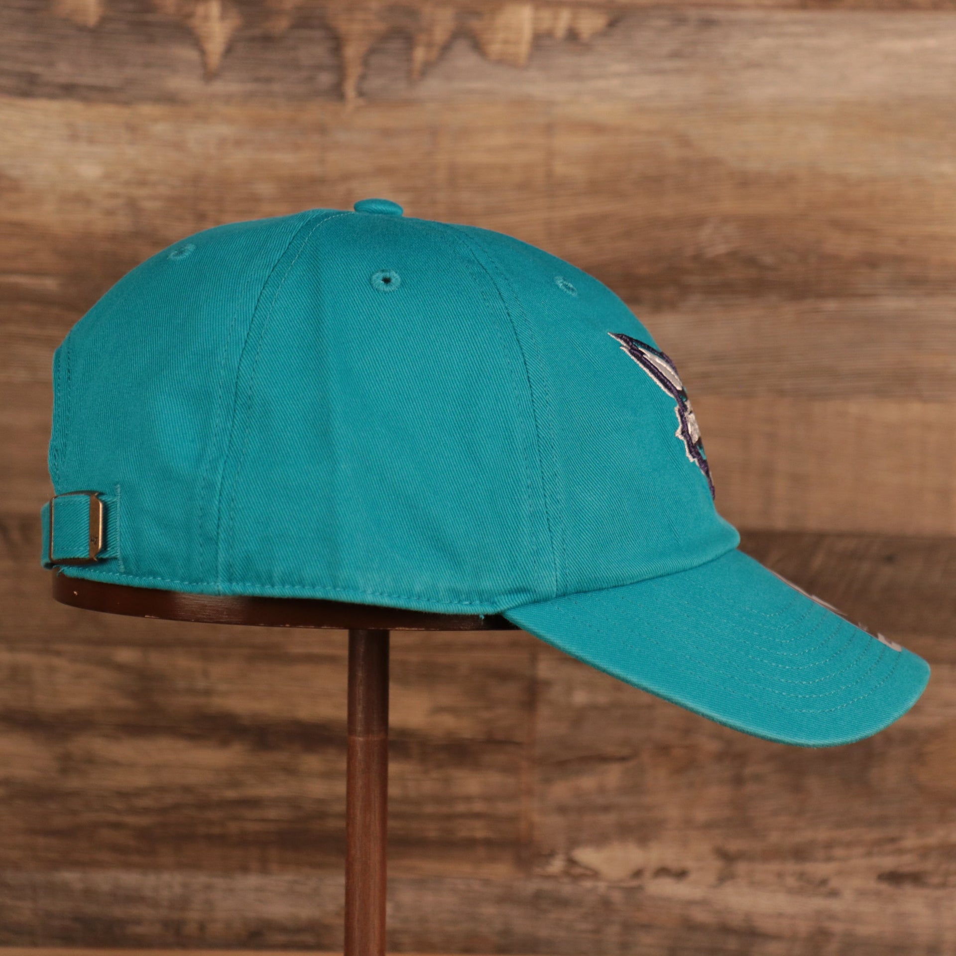 wearers right side of the Charlotte Hornets Cyan Adjustable Dad Hat
