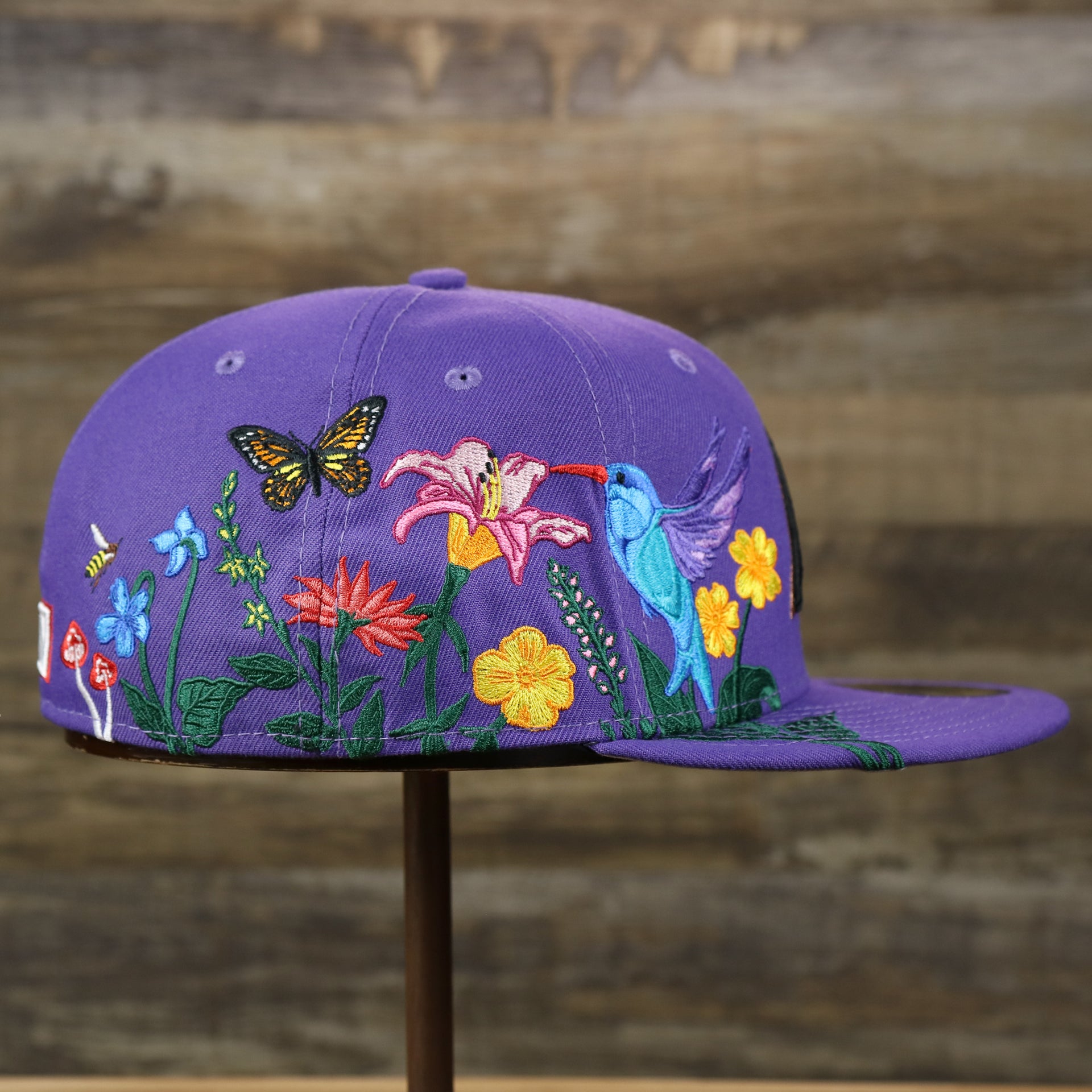 The wearer's right on the Cooperstown Arizona Diamondbacks Gray Bottom Bloom Spring Embroidery 59Fifty Fitted Cap | Purple 59Fifty Cap