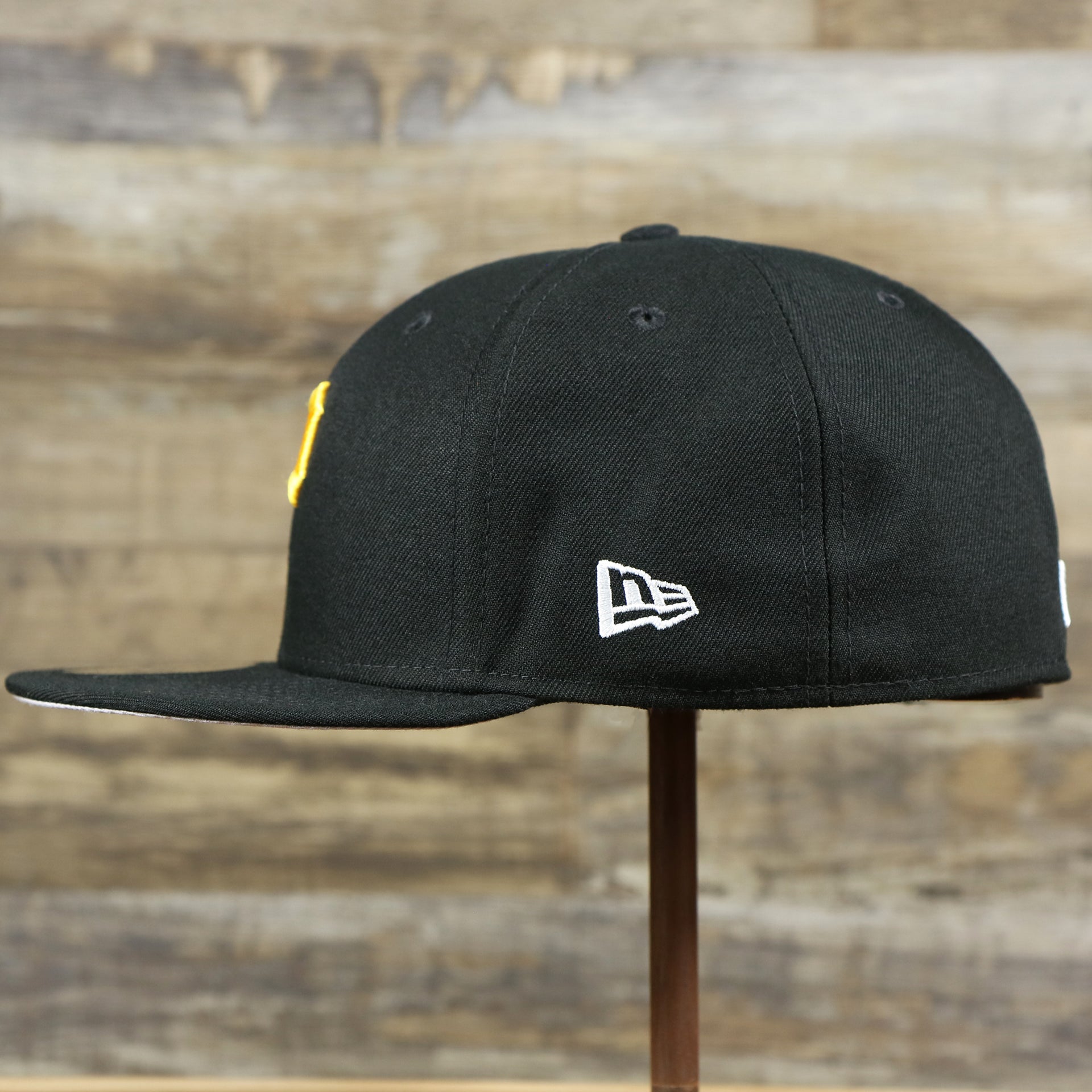 The wearer's left of the Pittsburgh Pirates Gray Bottom Bloom Spring Embroidery 59Fifty Fitted Cap | Black 59Fifty Cap