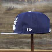 The wearer's left of the Georgetown Hoyas Team Script Gray Bottom 9Fifty Snapback | Navy Blue And Gray Snap Cap