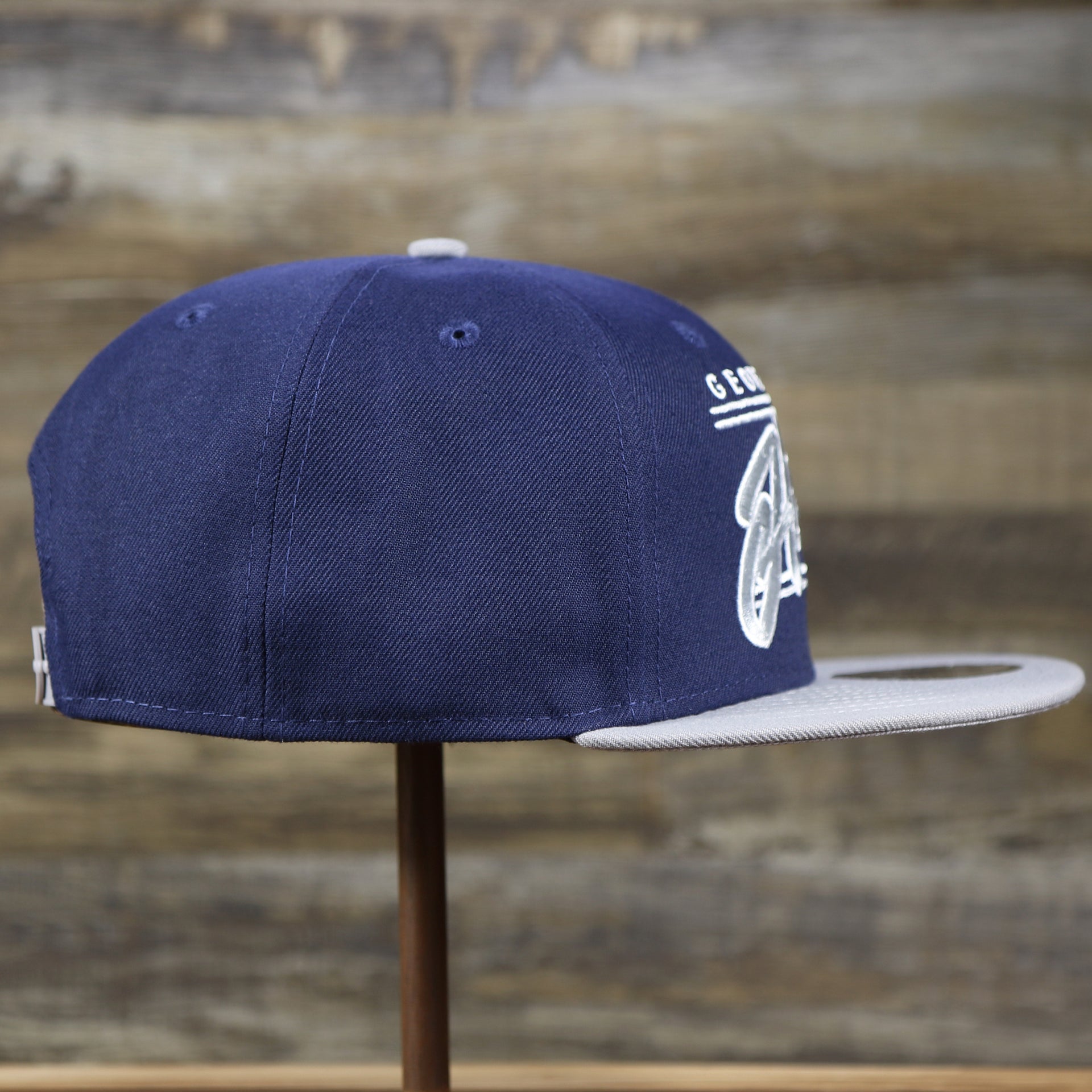 The wearer's right on the Georgetown Hoyas Team Script Gray Bottom 9Fifty Snapback | Navy Blue And Gray Snap Cap