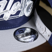 The 9Fifty Sticker on the Georgetown Hoyas Team Script Gray Bottom 9Fifty Snapback | Navy Blue And Gray Snap Cap