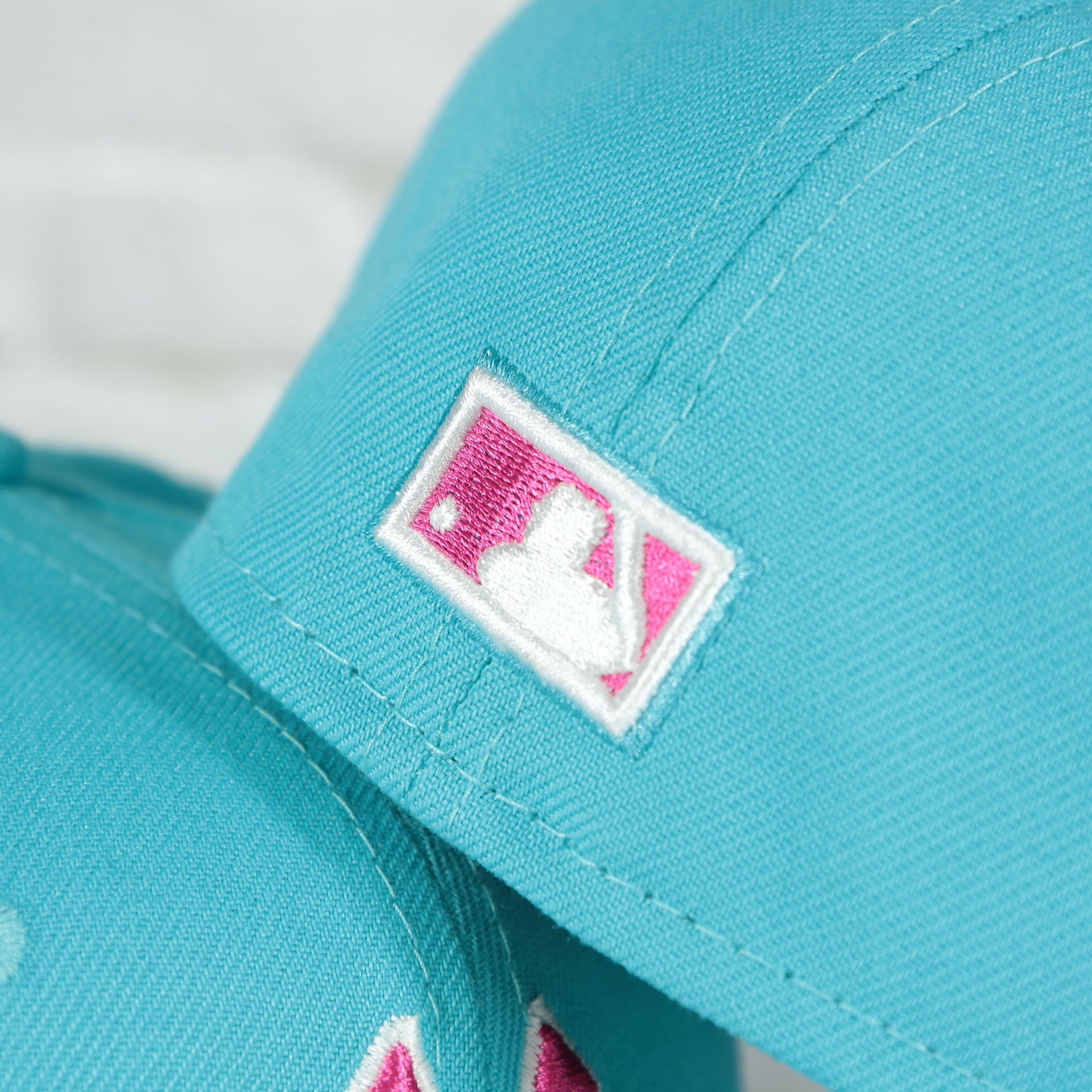 Close up of the MLB Batterman logo on the back of the New York Yankees Cooperstown 2008 All Star Game Magenta Under Bottom 59FIFTY Fitted Cap | Vice Blue Pack