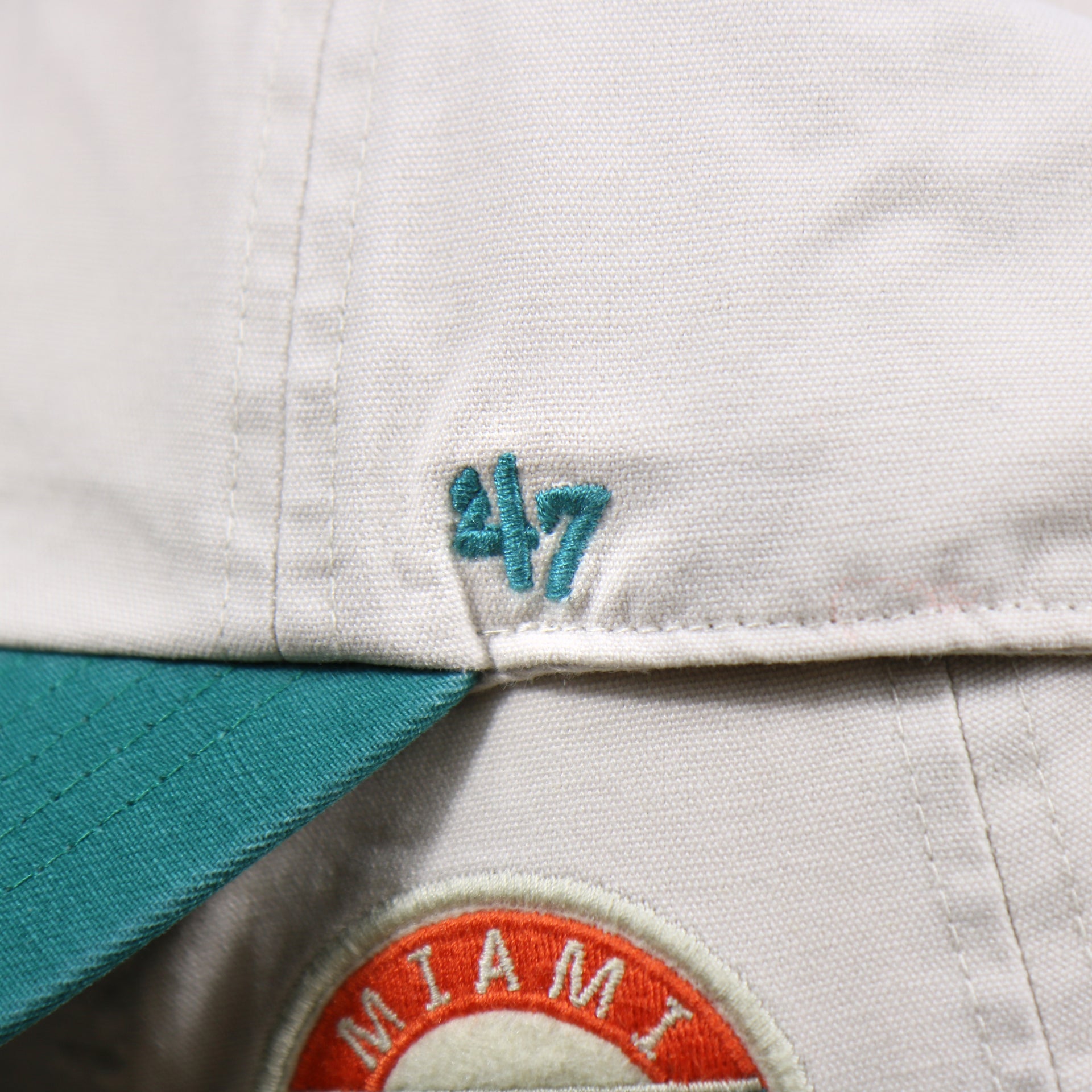 The 47 Brand Logo on the Throwback Miami Dolphins NFL Wordmark Side Patch Legacy Dad Hat | Bone Dad Hat
