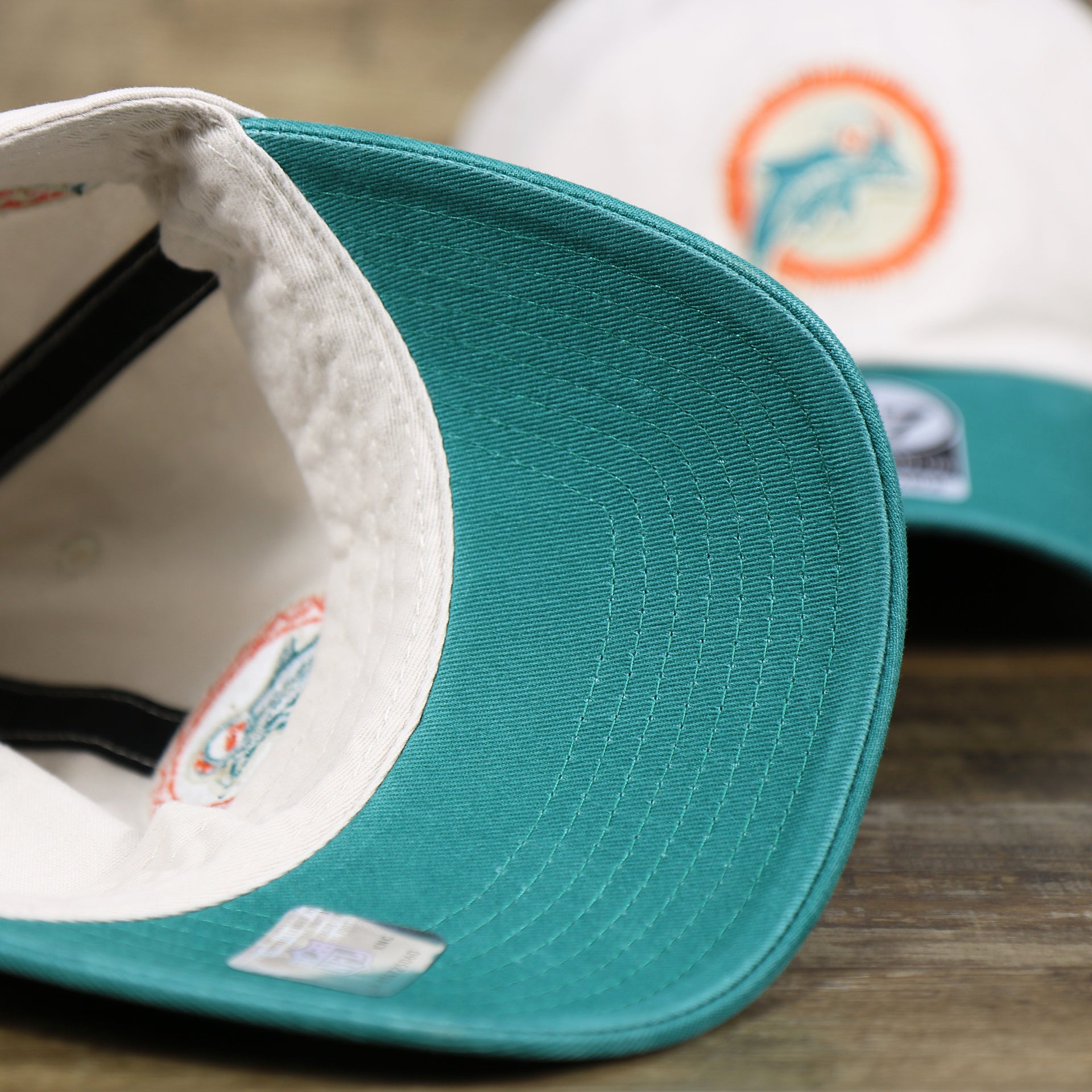 The teal undervisor on the Throwback Miami Dolphins NFL Wordmark Side Patch Legacy Dad Hat | Bone Dad Hat
