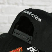 mitchell and ness logo on the Chicago Bulls Vintage Retro NBA Champions 1997 Mitchell and Ness Snapback Hat | Black
