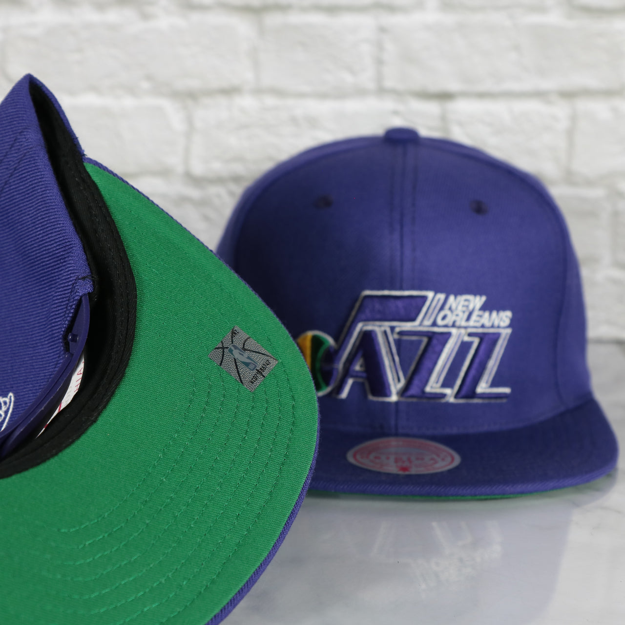 green under visor on the New Orleans Jazz Vintage Retro NBA Team Ground 2.0 Mitchell and Ness Snapback Hat | Purple