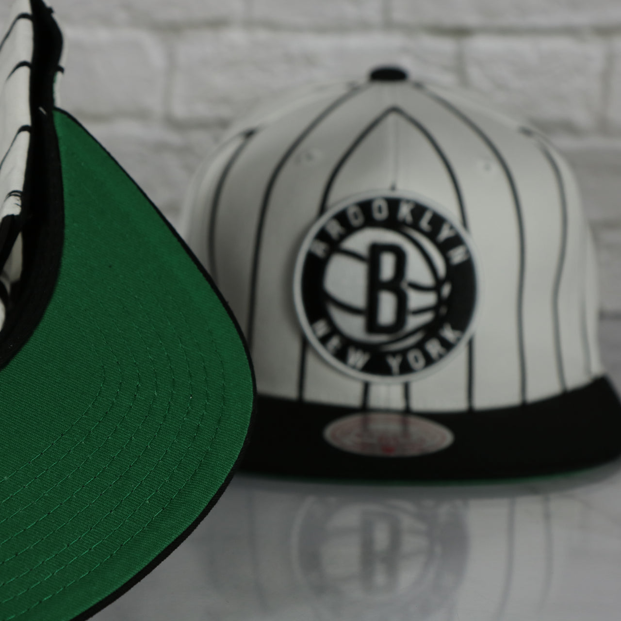 green under visor on the Brooklyn Nets Vintage Pinstripe Baseball Hat | Retro Mitchell and Ness White Pinstripe Snapback Hat