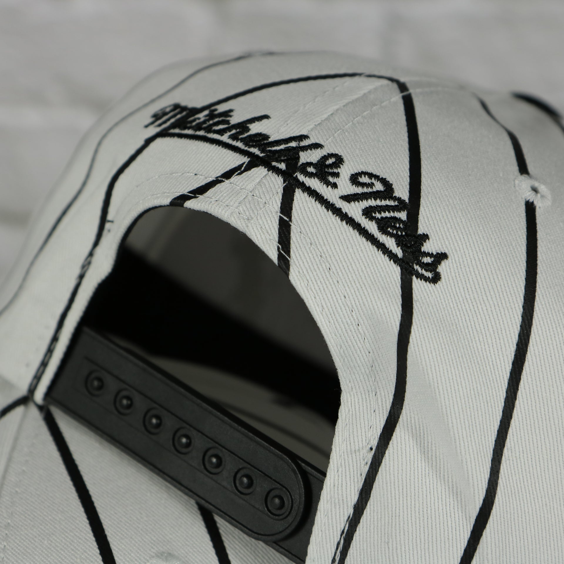 mitchell and ness logo on the Brooklyn Nets Vintage Pinstripe Baseball Hat | Retro Mitchell and Ness White Pinstripe Snapback Hat