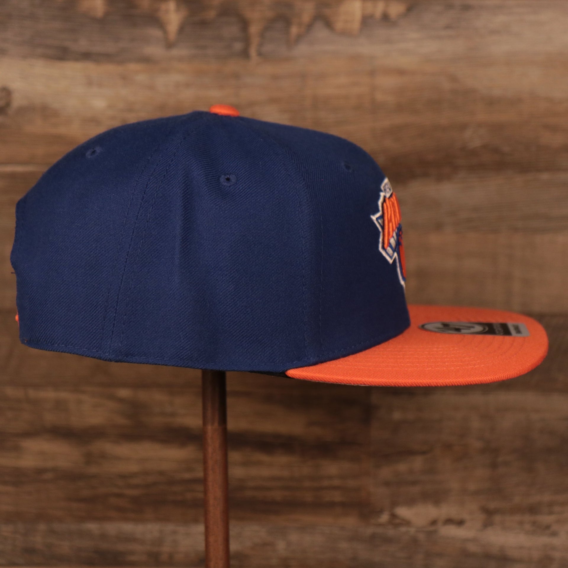 wearers right side of the New York Knicks Royal Blue and Orange Adjustable Grey Bottom Snapback Hat