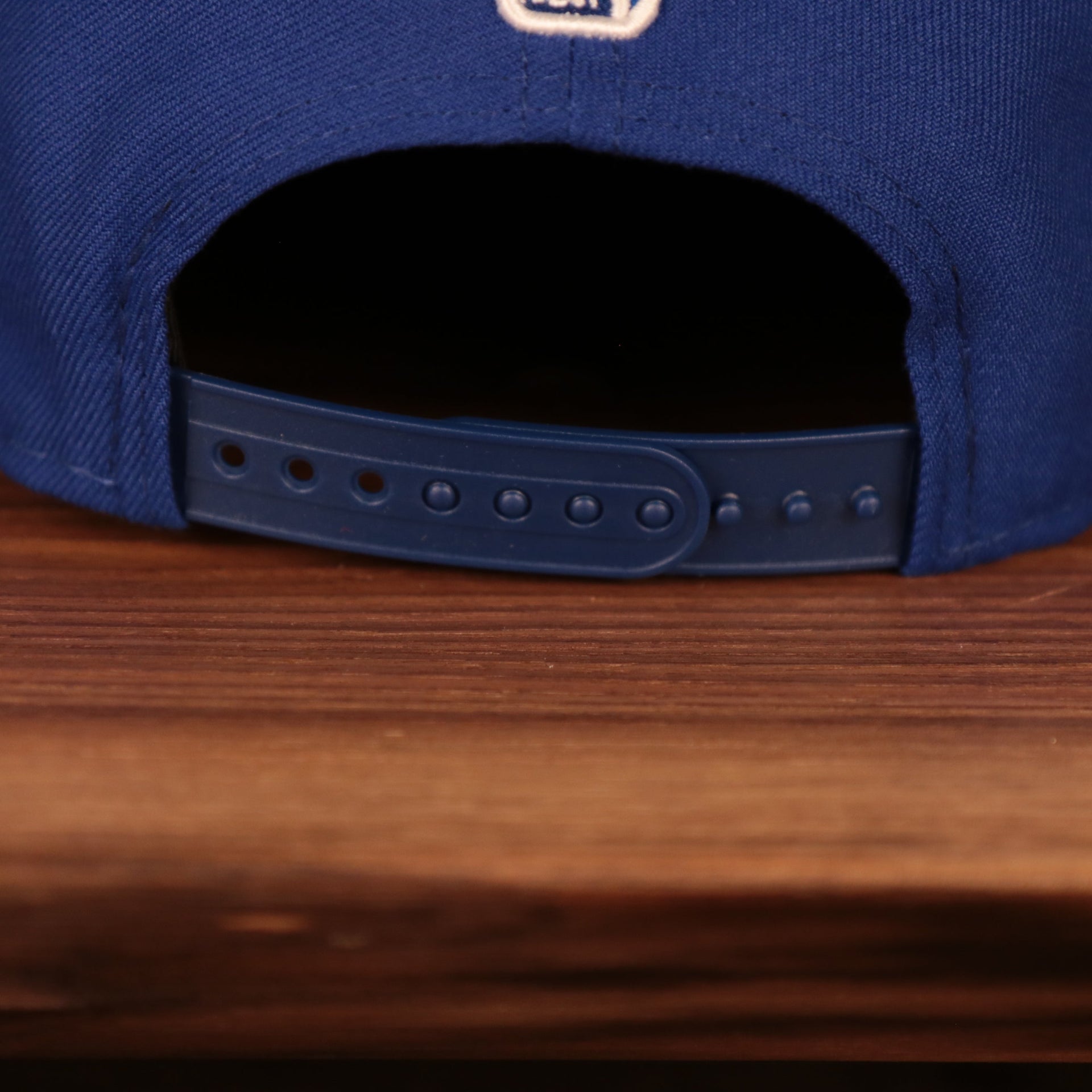 A close up shot of the adjustable snap closure found on the back of the New York Knicks 2021 NBA Playoffs snapback hat