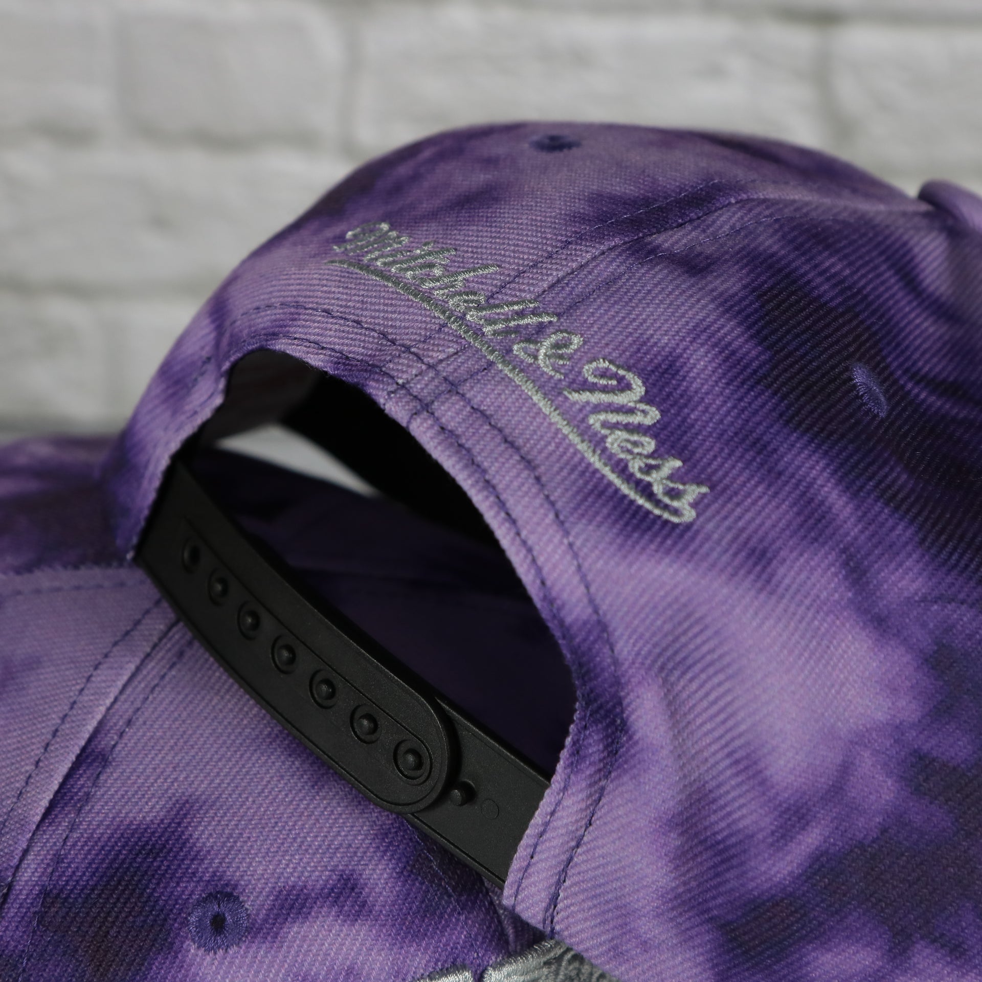 mtichell and ness logo on the Toronto Raptors Galaxy Purple Reflective Script Mitchell and Ness Snapback Hat