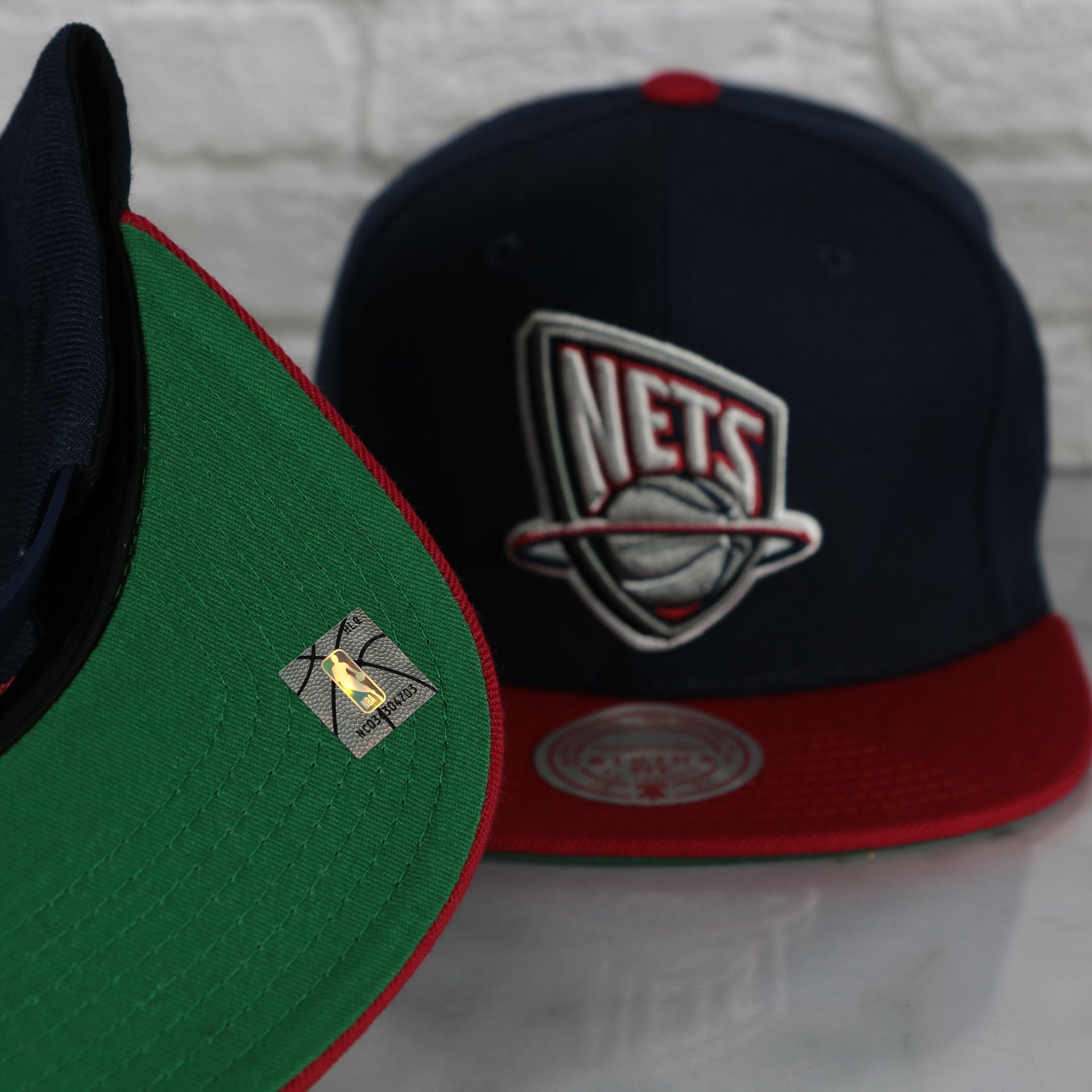 green under visor on the New Jersey Nets Vintage Retro NBA Team 2 Tone Mitchell and Ness Snapback Hat | Navy/Red
