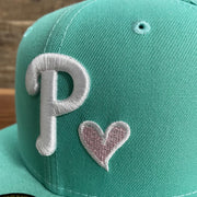 Close up of the heart logo on the 2008 World Series Philadelphia Phillies Heart Pink Bottom 5950 Fitted | "Mint Flamingo"