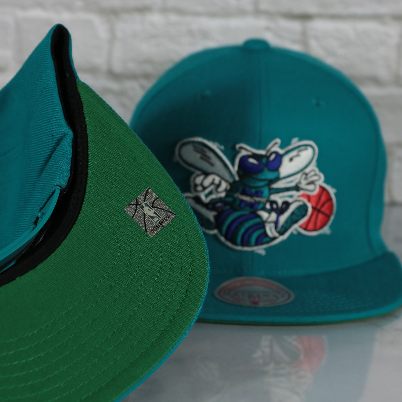 green under visor on the Charlotte Hornets Vintage Retro NBA Team Ground 2.0 Mitchell and Ness Snapback Hat | Teal