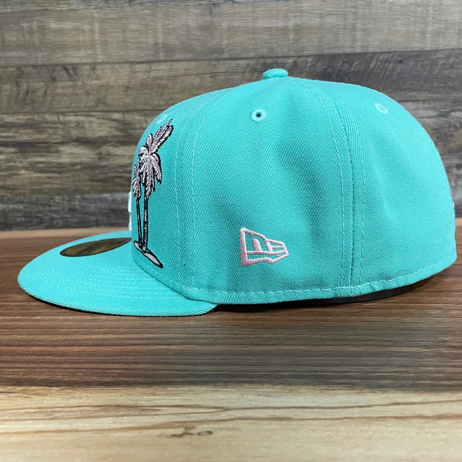 Wearer's left of the 50th Anniversary Los Angeles Dodgers Palm Tree Pink Bottom Side Patch 5950 Fitted | "Mint Flamingo"