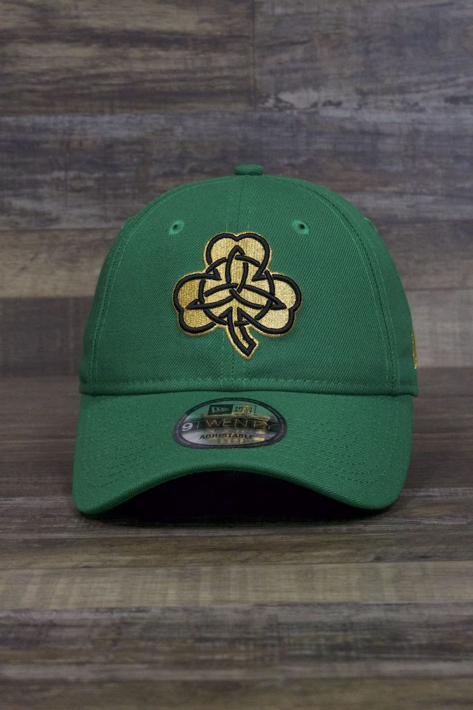 the Boston Celtics 2019 City Series Dad Hat | Irish Green Adjustable Boston Celtics Baseball Cap with Golden Shamrock has a large gold shamrock on the front