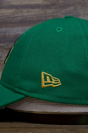 the Boston Celtics 2019 City Series Dad Hat | Irish Green Adjustable Boston Celtics Baseball Cap with Golden Shamrock has a gold new era logo on the side