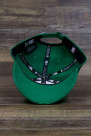 the bottom of the Boston Celtics 2019 City Series Dad Hat | Irish Green Adjustable Boston Celtics Baseball Cap with Golden Shamrock has a green underbrim