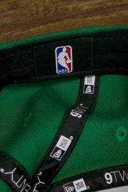 the inside of the Boston Celtics 2019 City Series Dad Hat | Irish Green Adjustable Boston Celtics Baseball Cap with Golden Shamrock has the NBA logo on a black sweatband