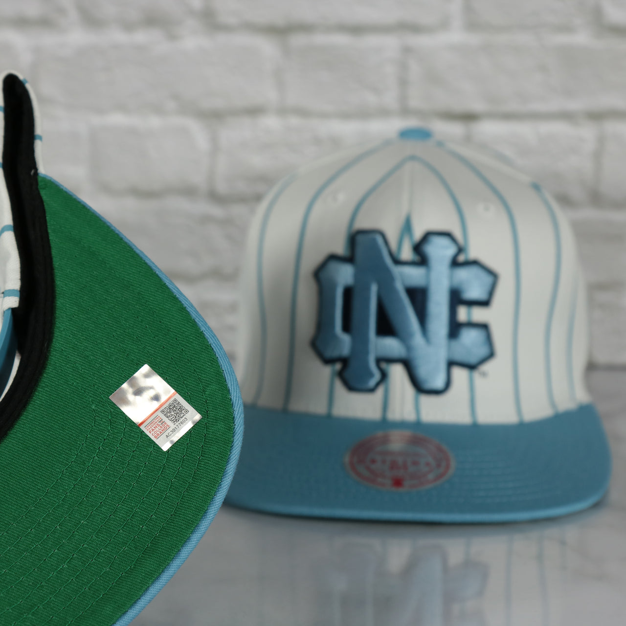 green under visor on the University of North Carolina Tar Heels Vintage Pinstripe Baseball Hat | Retro Mitchell and Ness White Pinstripe Snapback Hat