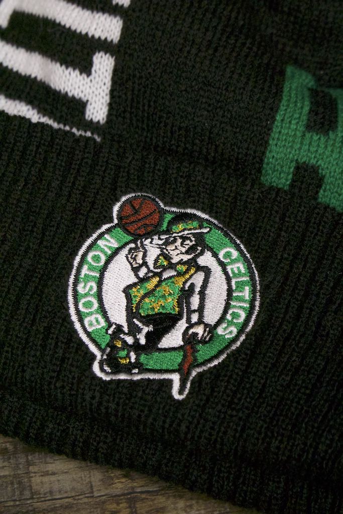 the leprechaun on the Boston Celtics 2019 Series Tip Off Black Winter Beanie | Oversized Wordmark Celtics Beanie with Retro Leprechaun Logo is embroidered on the front as a patch