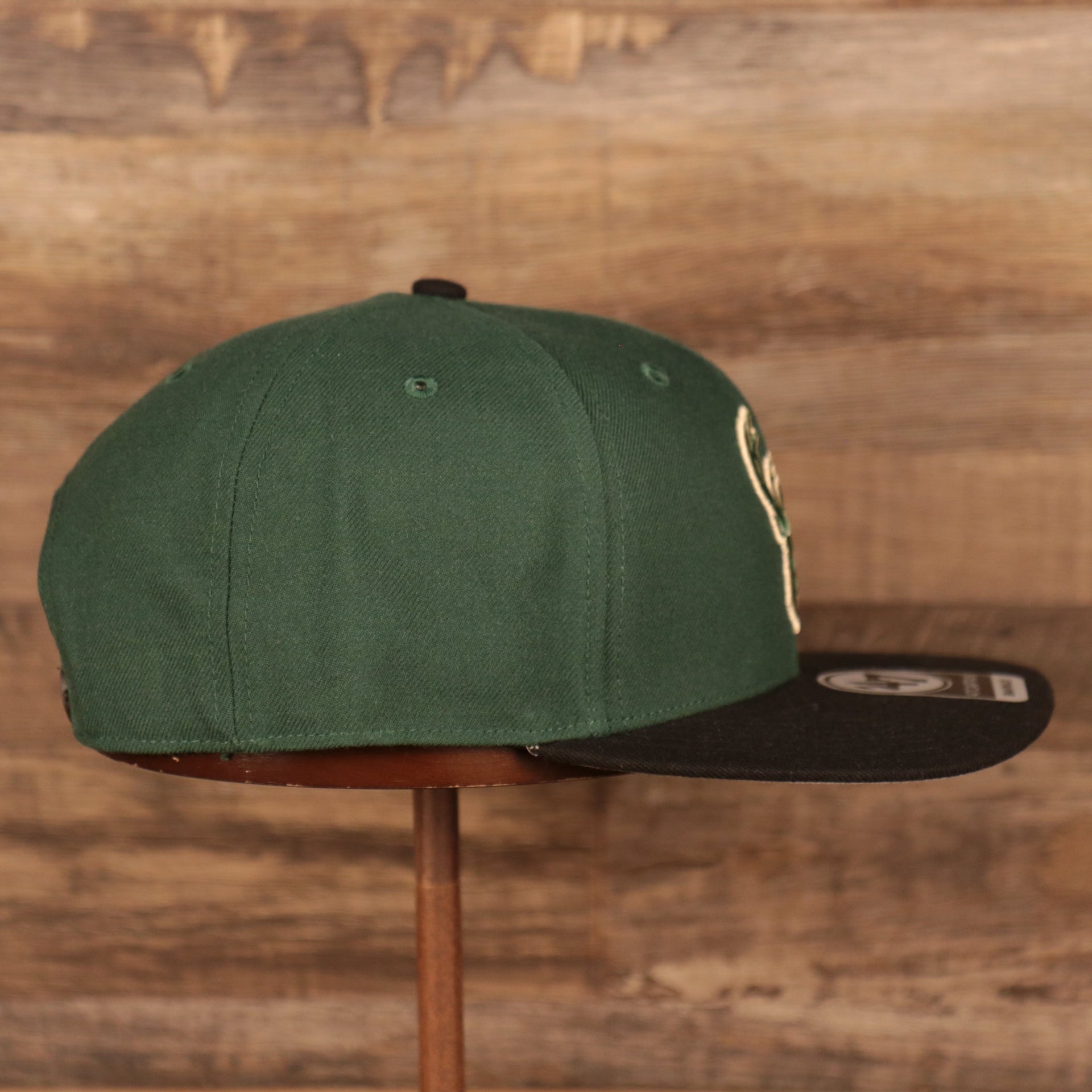 wearers right side on the Milwaukee Bucks Dark Green and Black Adjustable Grey Bottom Snapback Hat