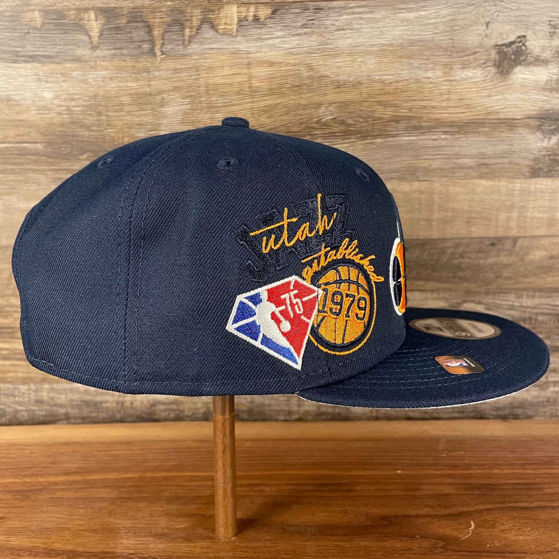 Wearer's right of the Utah Jazz NBA 75th Anniversary Side Patch Gray Bottom Navy 9Fifty Snapback Hat | Back Half