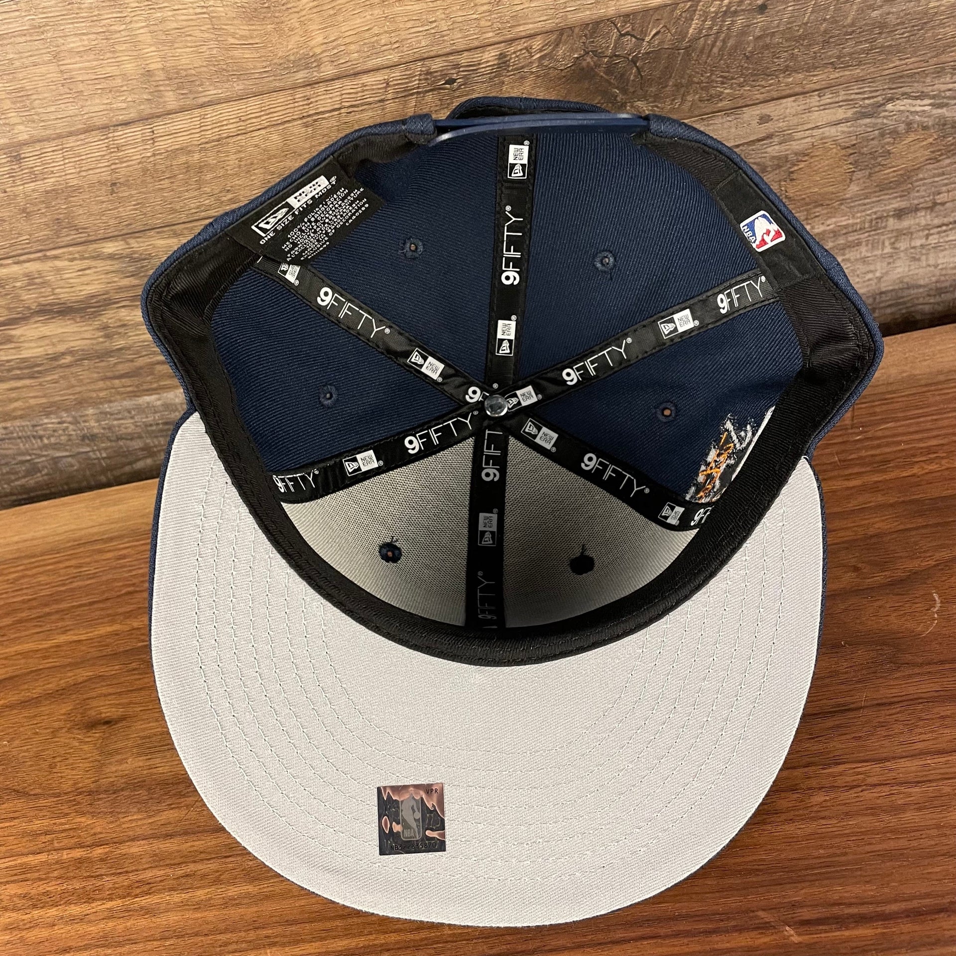 Gray under visor of the Utah Jazz NBA 75th Anniversary Side Patch Gray Bottom Navy 9Fifty Snapback Hat | Back Half